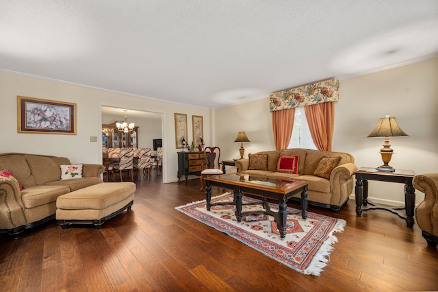 living room featuring ornamental molding, dark hardwood / wood-style flooring, and a notable chandelier