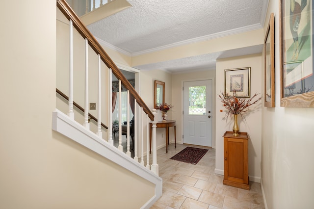 foyer entrance featuring a textured ceiling and ornamental molding