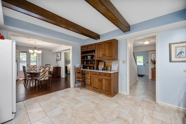 kitchen featuring a notable chandelier, plenty of natural light, white refrigerator, and hanging light fixtures