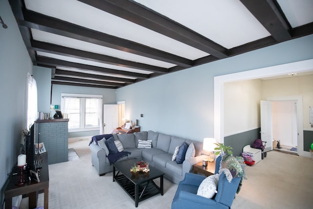 carpeted living room featuring beamed ceiling