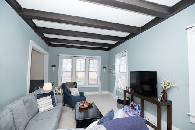 carpeted living room with a wealth of natural light and beam ceiling