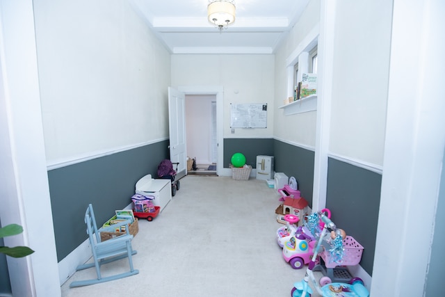 playroom with carpet floors and beam ceiling