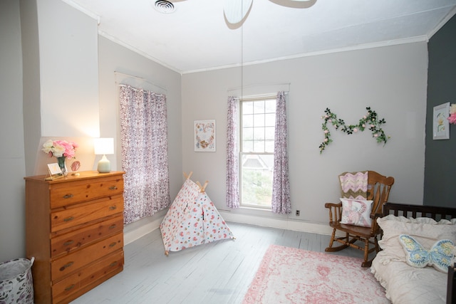 bedroom with light wood-type flooring, ceiling fan, and ornamental molding