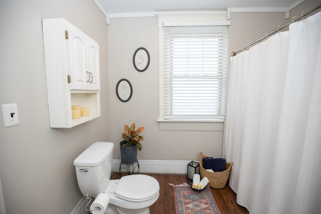 bathroom with hardwood / wood-style flooring, toilet, and ornamental molding