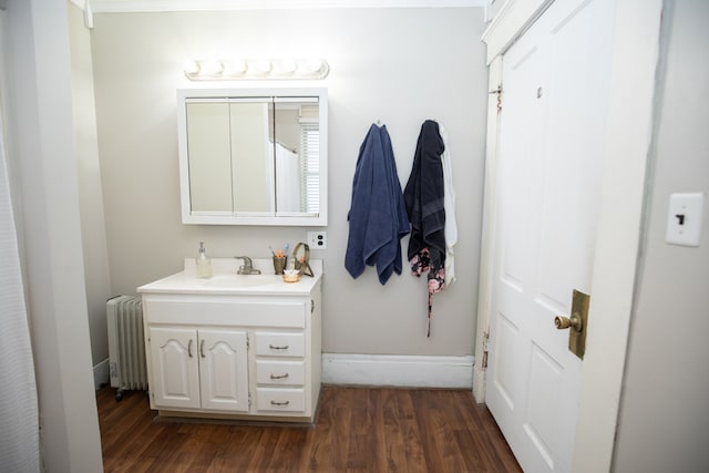 bathroom featuring radiator heating unit, hardwood / wood-style flooring, and vanity