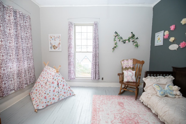 bedroom with ornamental molding, hardwood / wood-style floors, and multiple windows