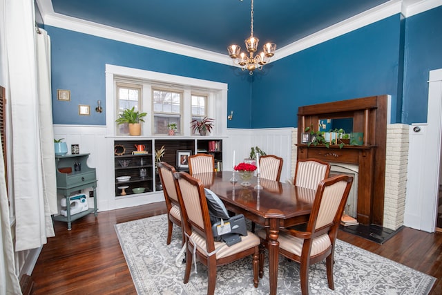 dining room with crown molding, dark hardwood / wood-style floors, and an inviting chandelier