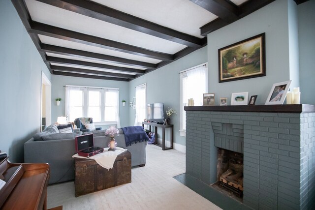 living room with a brick fireplace, beam ceiling, and plenty of natural light