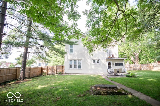 rear view of house featuring a patio and a yard