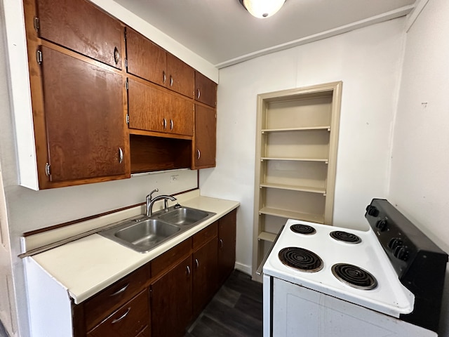 kitchen with stove, dark wood-type flooring, and sink