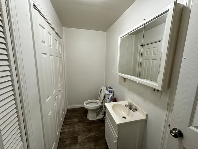 bathroom with hardwood / wood-style floors, oversized vanity, and toilet