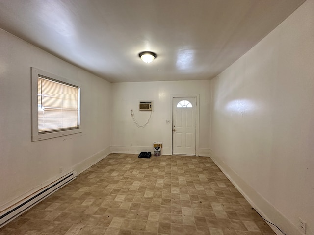 laundry area with a wall mounted AC, a baseboard heating unit, and light tile floors