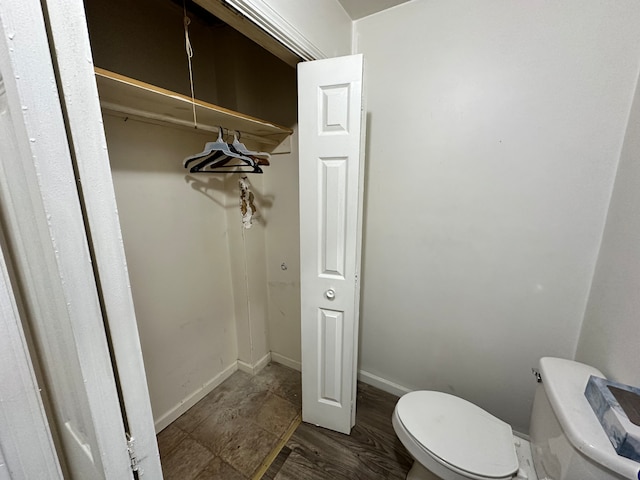 interior space with toilet and hardwood / wood-style flooring