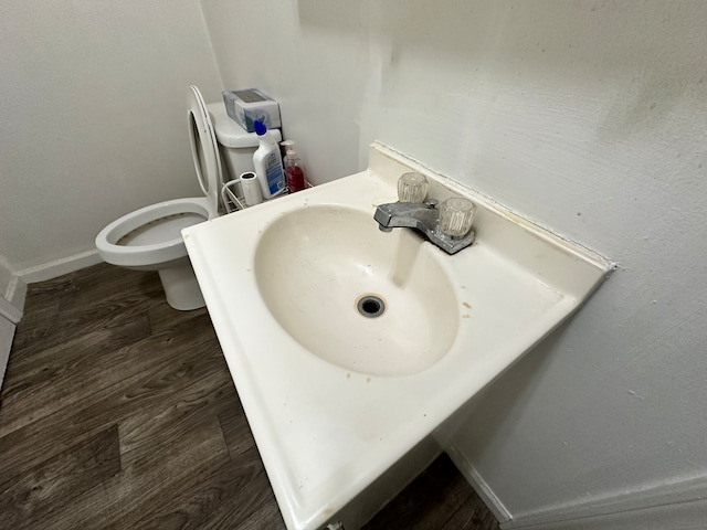 bathroom with toilet and wood-type flooring