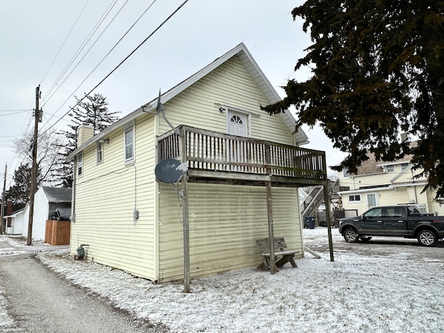 snow covered property featuring a wooden deck