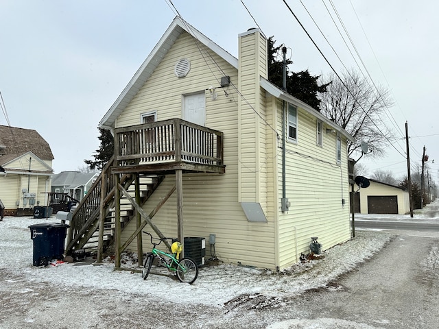 back of house with a deck, central AC, and a garage