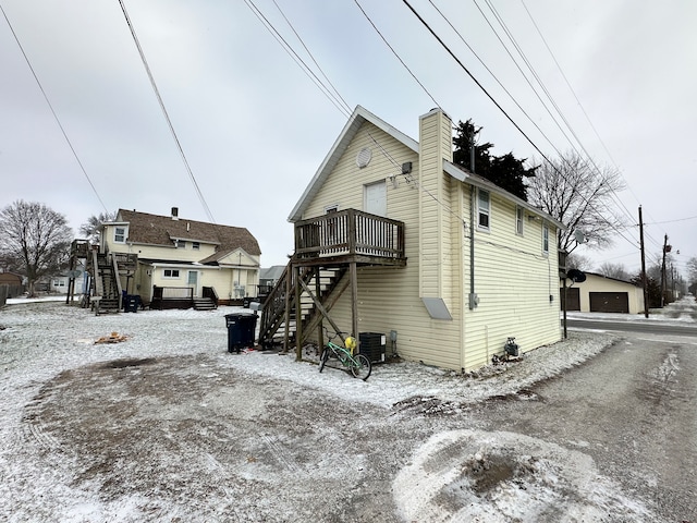 view of snow covered exterior featuring a wooden deck and central air condition unit