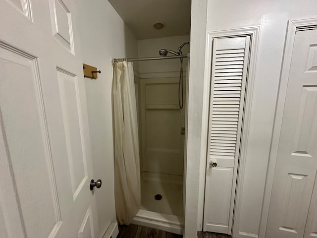 bathroom with walk in shower and wood-type flooring