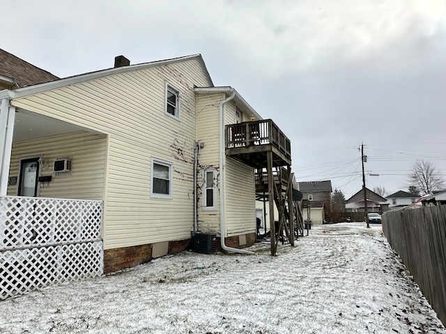 snow covered property with central AC unit