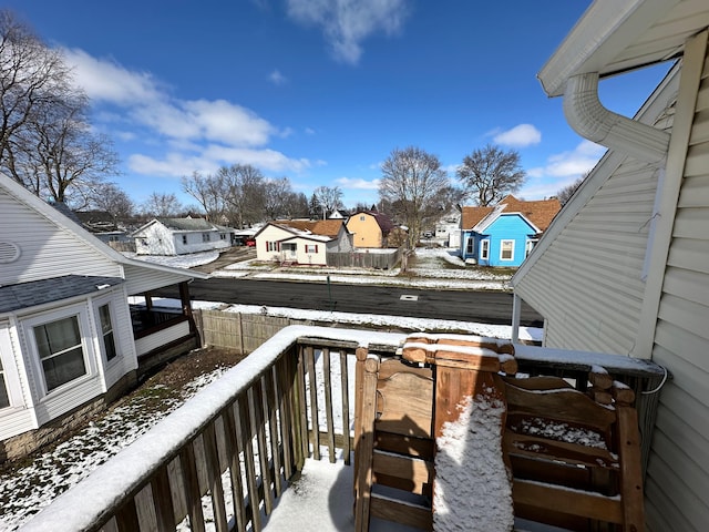 view of snow covered back of property