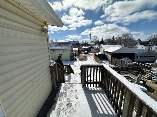 view of snow covered back of property