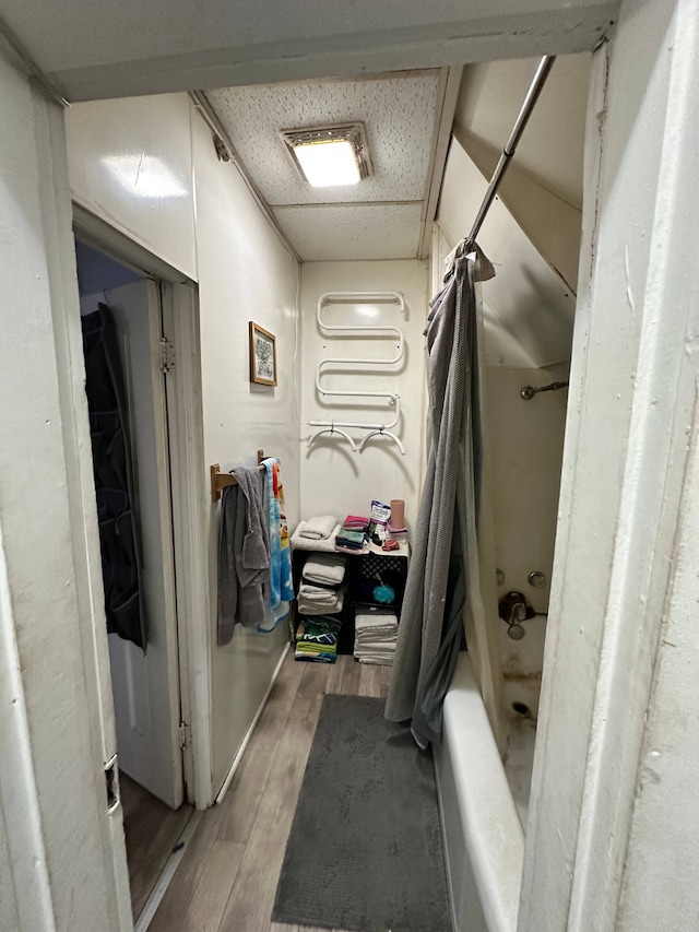 bathroom with shower / washtub combination and hardwood / wood-style flooring