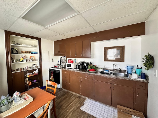 kitchen featuring a drop ceiling, white appliances, sink, and dark wood-type flooring