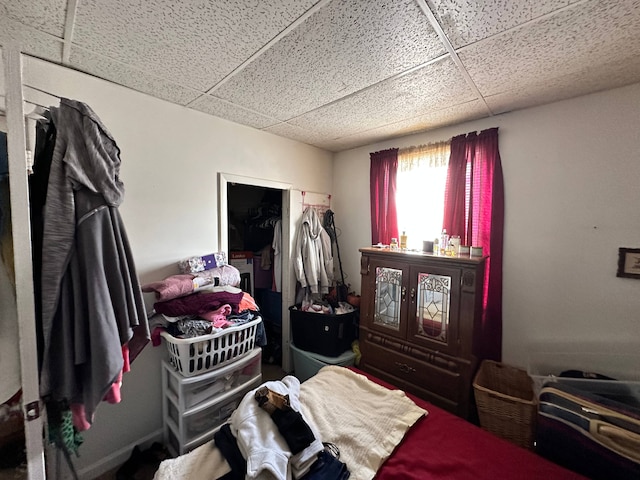 bedroom with a paneled ceiling and a closet