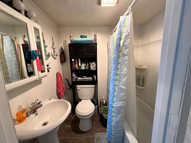 full bathroom with toilet, shower / bathtub combination with curtain, hardwood / wood-style flooring, and sink