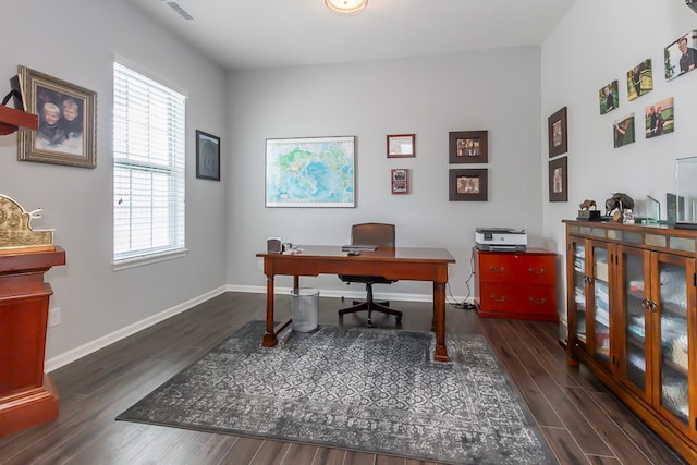 office with dark hardwood / wood-style flooring and a healthy amount of sunlight