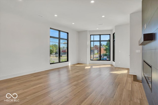 unfurnished living room with a healthy amount of sunlight and light hardwood / wood-style flooring