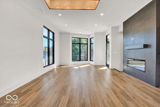 unfurnished living room featuring a fireplace and light hardwood / wood-style floors