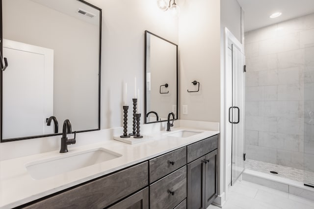 bathroom featuring walk in shower, dual sinks, tile floors, and large vanity