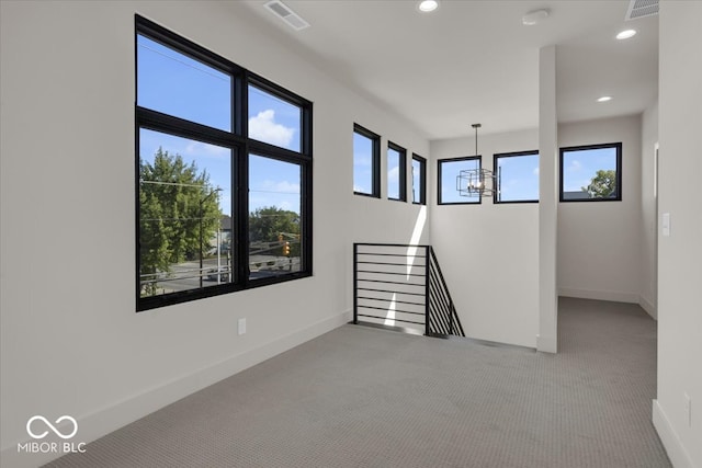 spare room with a chandelier and carpet floors