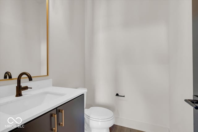 bathroom featuring vanity, toilet, and hardwood / wood-style floors