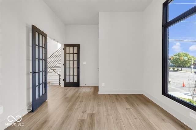 empty room with french doors and light hardwood / wood-style flooring