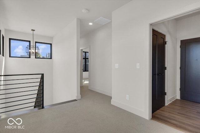 spare room with hardwood / wood-style floors and an inviting chandelier