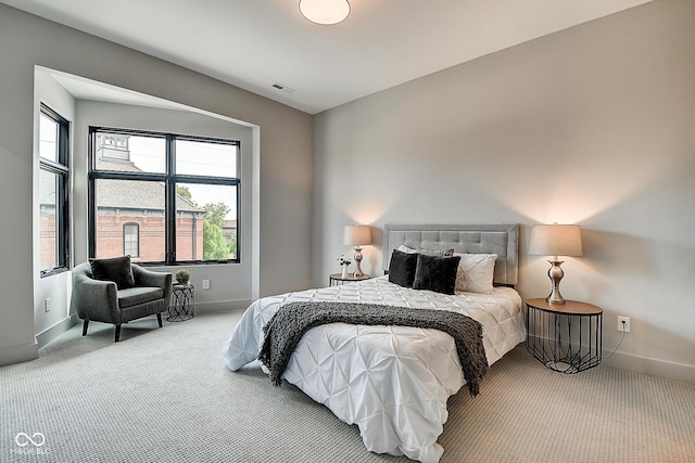 bedroom with carpet floors, visible vents, baseboards, and multiple windows