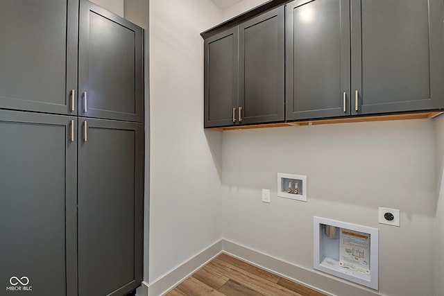 laundry area featuring washer hookup, cabinet space, light wood-style floors, electric dryer hookup, and baseboards