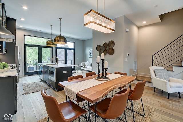 dining space featuring baseboards, visible vents, stairs, light wood-type flooring, and recessed lighting