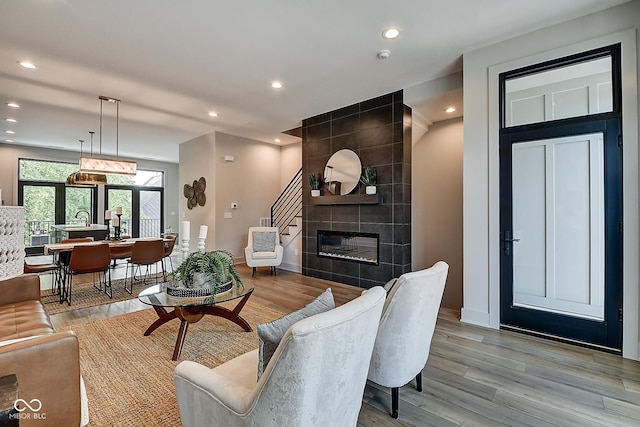 living room with recessed lighting, baseboards, light wood-style flooring, and a tile fireplace