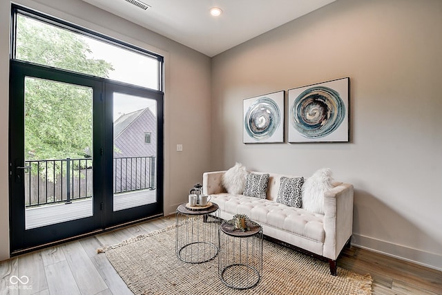 living room featuring recessed lighting, light wood-type flooring, and baseboards