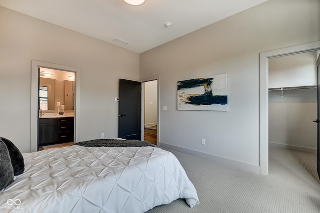 bedroom featuring light carpet, visible vents, baseboards, a spacious closet, and a closet