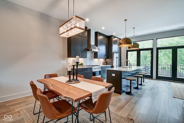 dining area featuring light wood finished floors, recessed lighting, and baseboards