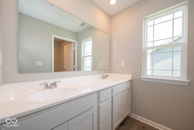 bathroom with double sink, hardwood / wood-style flooring, and large vanity