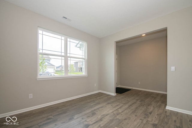 empty room with dark hardwood / wood-style flooring