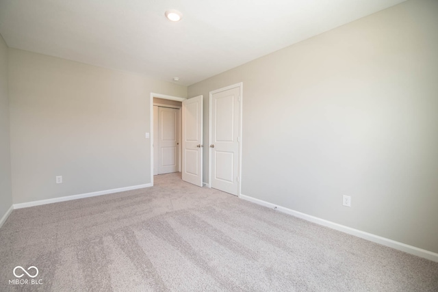 unfurnished room featuring light carpet