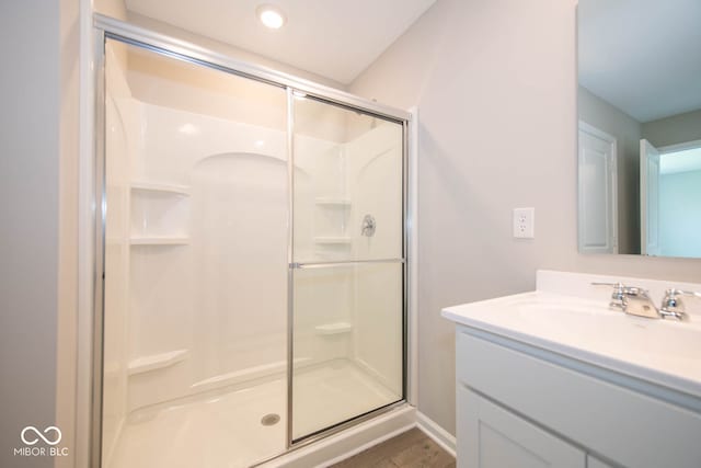 bathroom with walk in shower, hardwood / wood-style flooring, and oversized vanity