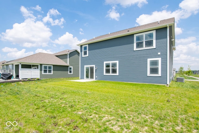 back of house featuring central AC unit and a lawn