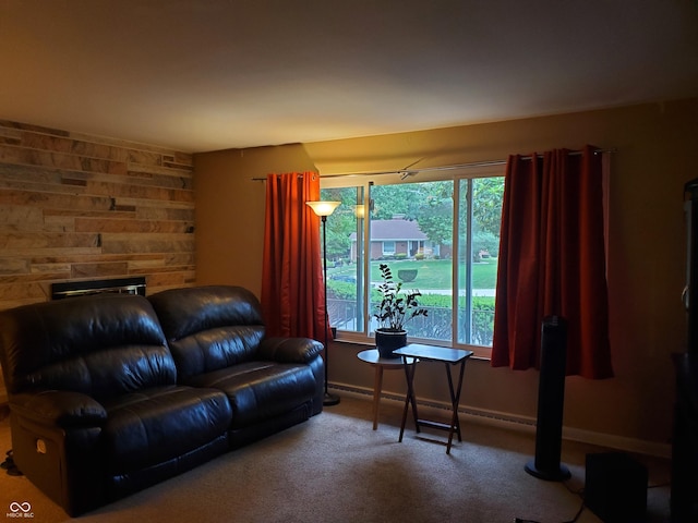 carpeted living room with a stone fireplace and wood walls